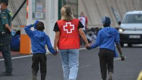 Una trabajadora de Cruz Roja escolta a dos menores inmigrantes de Canarias, en una foto de archivo.