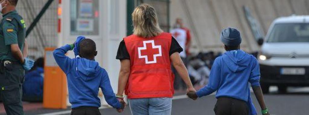 Una trabajadora de Cruz Roja escolta a dos menores inmigrantes de Canarias, en una foto de archivo.
