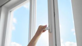 Mujer abriendo ventana.