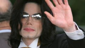 Michael Jackson saluda a sus seguidores al llegar al juzagado del Condado de Santa Bárbara (California), el 3 de junio de 2005, donde fue sometido a un juicio por abusos sexuales a menores del que salió absuelto. Foto: EFE/Connie Aramaki