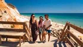 Varias personas visitando la Praia Da Falésia, en Portugal.