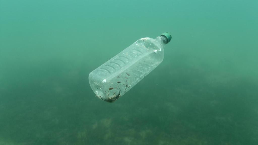 Una botella de plástico bajo el agua del mar.