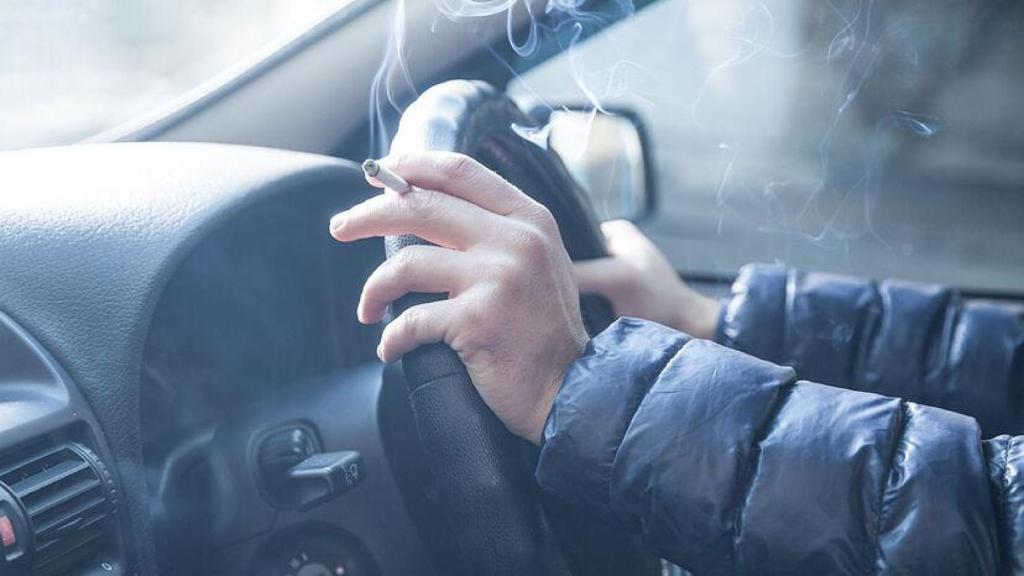 Imagen de archivo de una persona fumando en el interior de un coche.