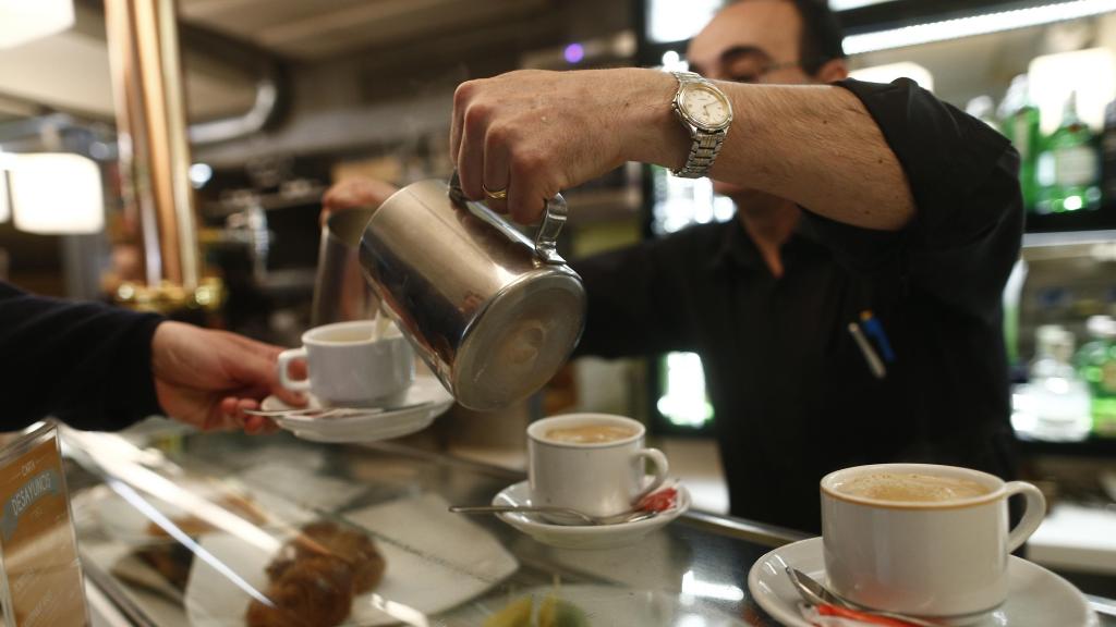 Un camarero sirviendo un café.