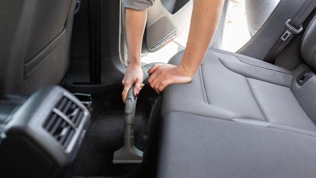 Una persona limpiando su coche por dentro.