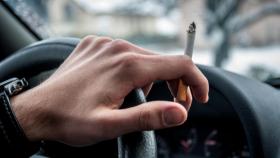 Un conductor fumando en el interior del coche.