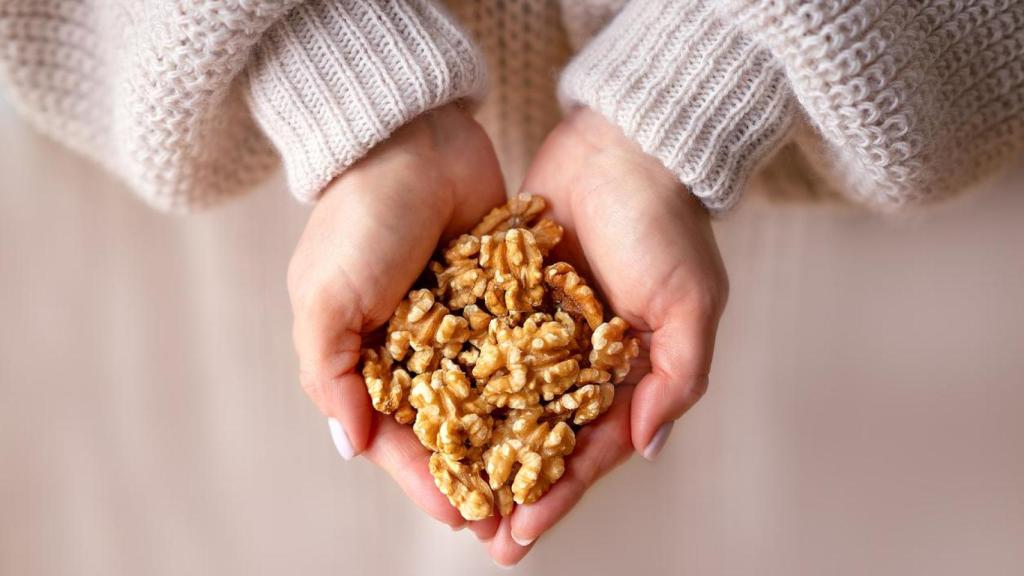 Manos sosteniendo un puñado de nueces.