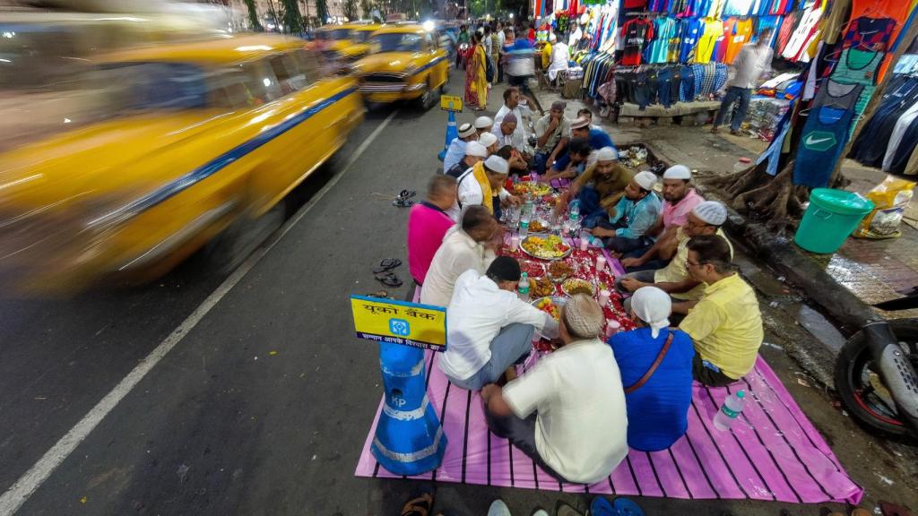 Un grupo de hombres cena en la calle en la India.
