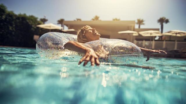 Mujer disfrutando en la piscina con un flotador.