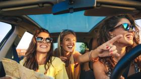 Amigas sonrientes dentro del coche.