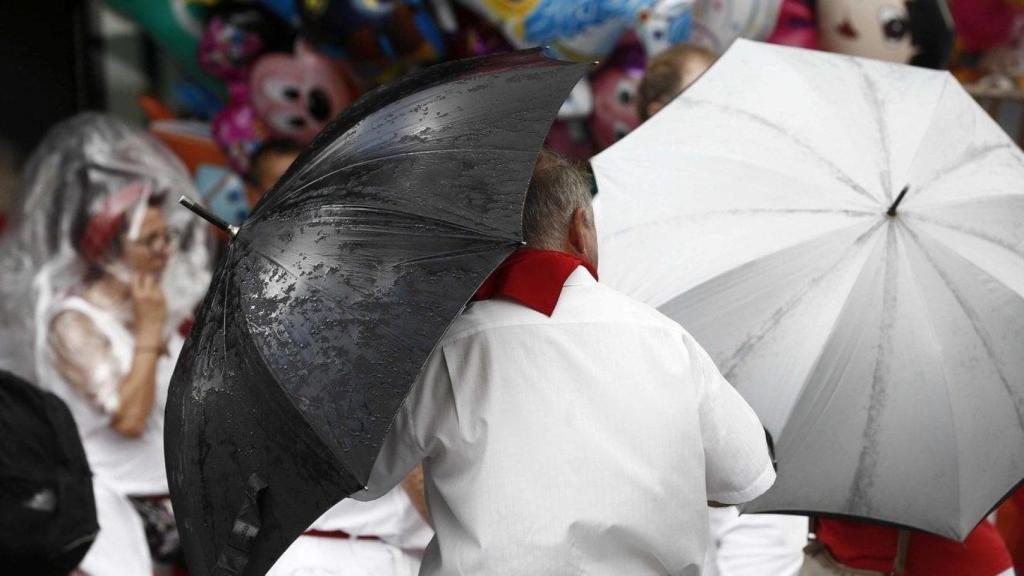 Varias personas bajo la lluvia durante las fiestas de San Fermín.