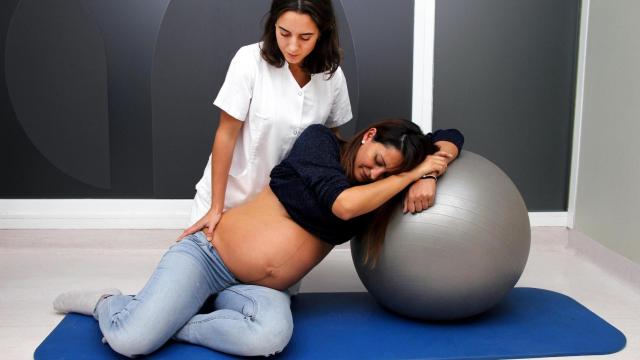 Una fisioterapeuta con una mujer embarazada.