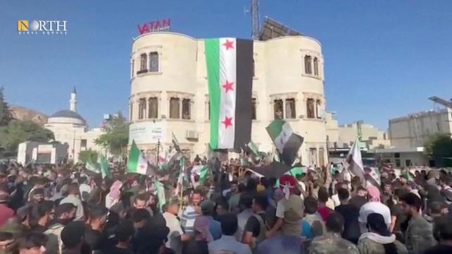 Una multitud de manifestantes se reúne con la bandera de la oposición siria en Azaz, este lunes.