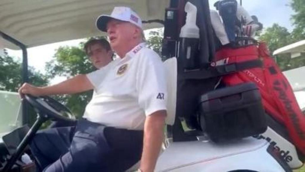 El candidato a la Casa Blanca, Donald Trump, acompañado de uno de sus hijos en un carro de golf.
