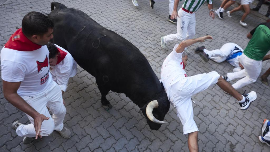 Un corredor es volteado por un toro durante un encierro de San Fermín 2023.