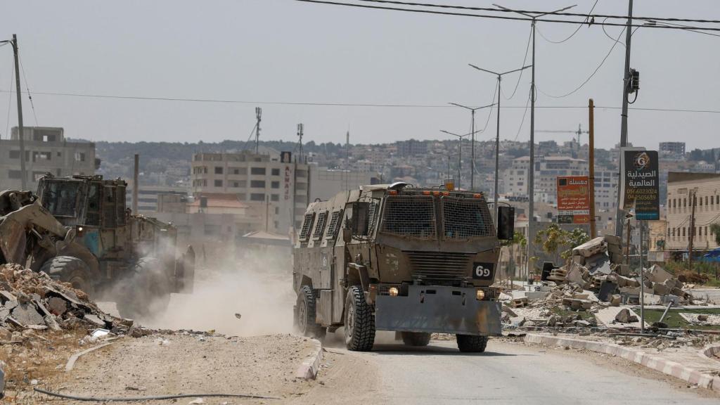 Vehículos israelíes circulan por la carretera el día de una redada israelí en el campamento de Jenin, en Cisjordania ocupada.