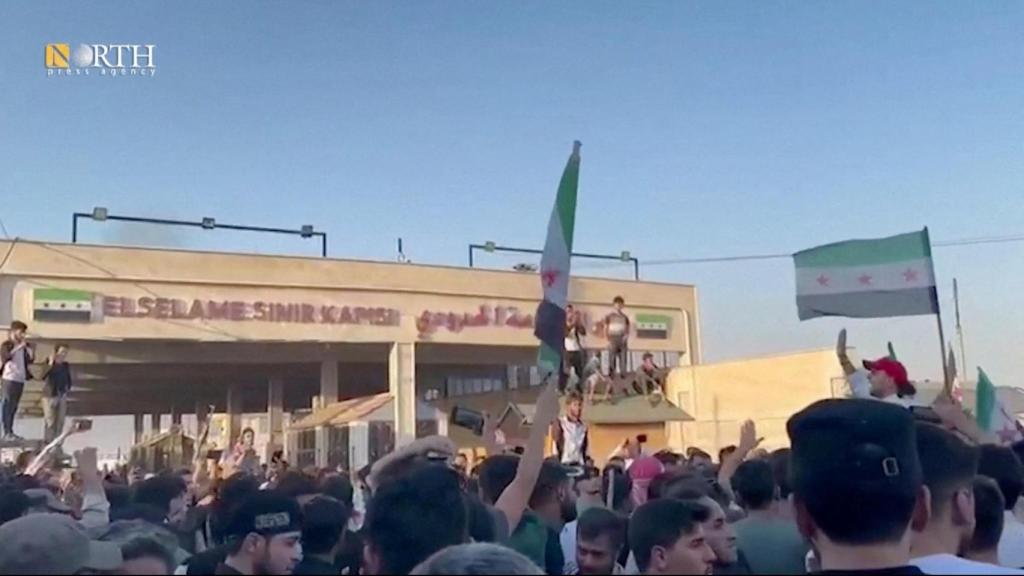 Manifestantes se reúnen con la bandera de la oposición siria en Bab al-Salameh, en la zona rural de Alepo, Siria.