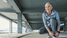 Mujer con ropa de deporte atándose los cordones.