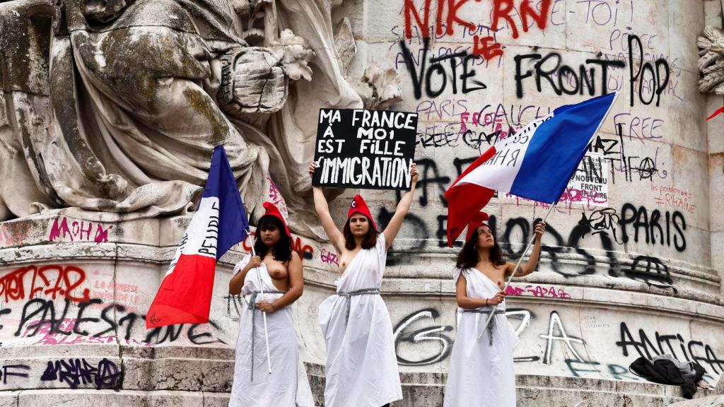 Tres mujeres se manifiestan contra la ultraderecha de Reagrupación Nacional en la plaza de la República de París.