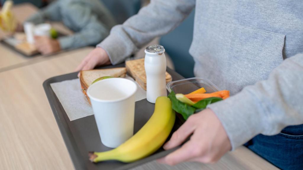 Un niño almuerza en un comedor escolar