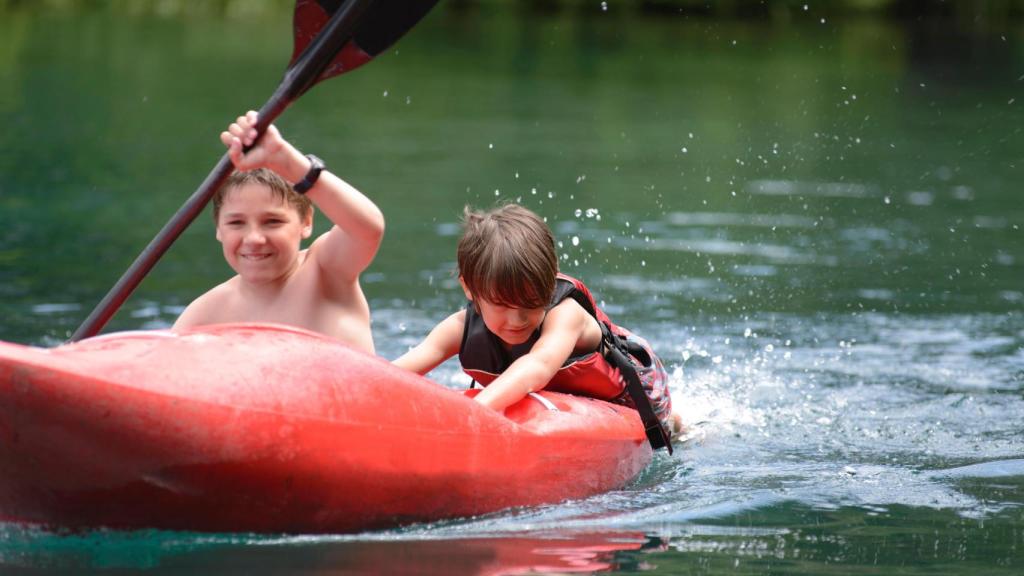 Dos niños practican kayak