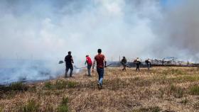 La gente trabaja para apagar incendios después de que Hezbolá lanzara proyectiles contra Israel.