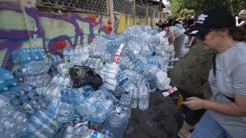 Cientos de personas depositan agua en la tapia del hospital infantil de Kiev tras el bombardeo ruso que redujo a escombros uno de los edificios del centro médico.