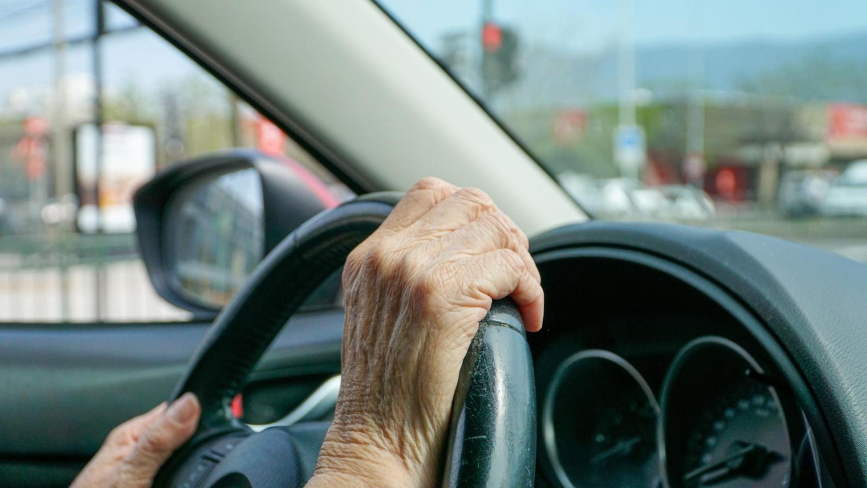 Persona mayor conduciendo.