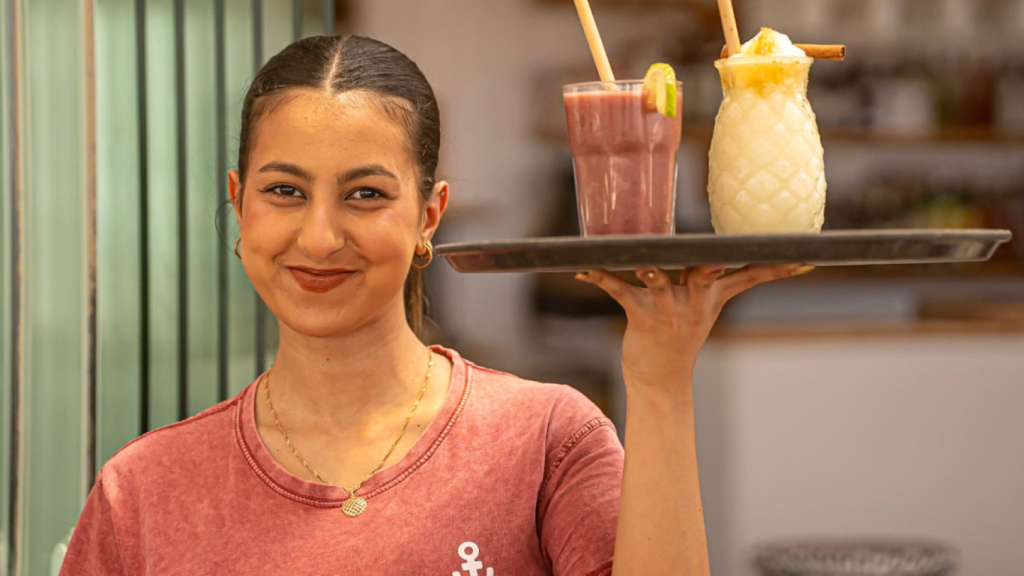 Una camarera sirviendo los zumos de Waikiki