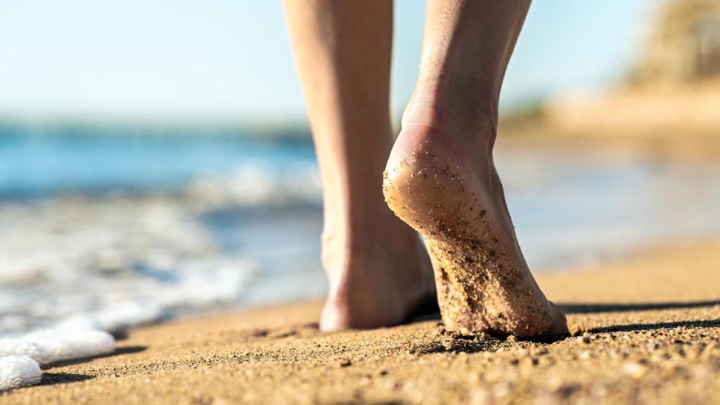 Una persona camina descalza por la playa