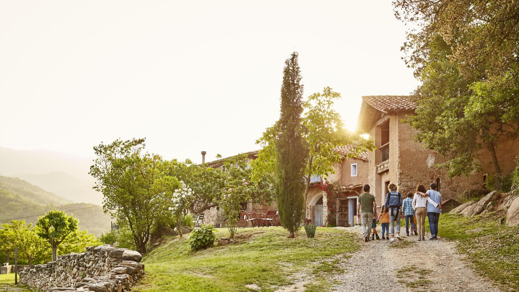 Vista posterior de una familia caminando en entorno rural.