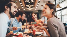 Grupo de amigos disfrutando de la comida en un restaurante.