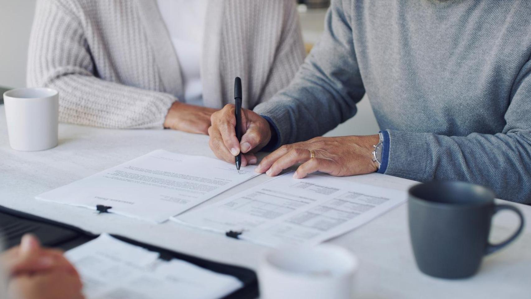 Dos personas firman un testamento.