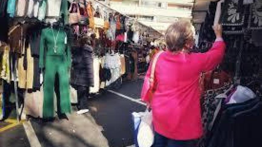 Una mujer viendo prendas en el mercadillo de Majadahonda.