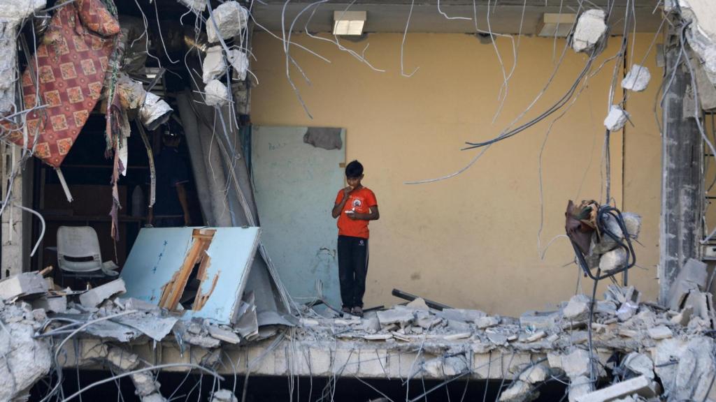 Palestinos inspeccionan un edificio derruido por los ataques israelíes en Gaza.