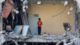 Palestinos inspeccionan un edificio derruido por los ataques israelíes en Gaza.
