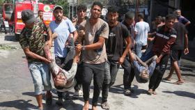 Palestinos trasladan a los heridos tras un ataque israelí en un campamento de tiendas en Mawasi.