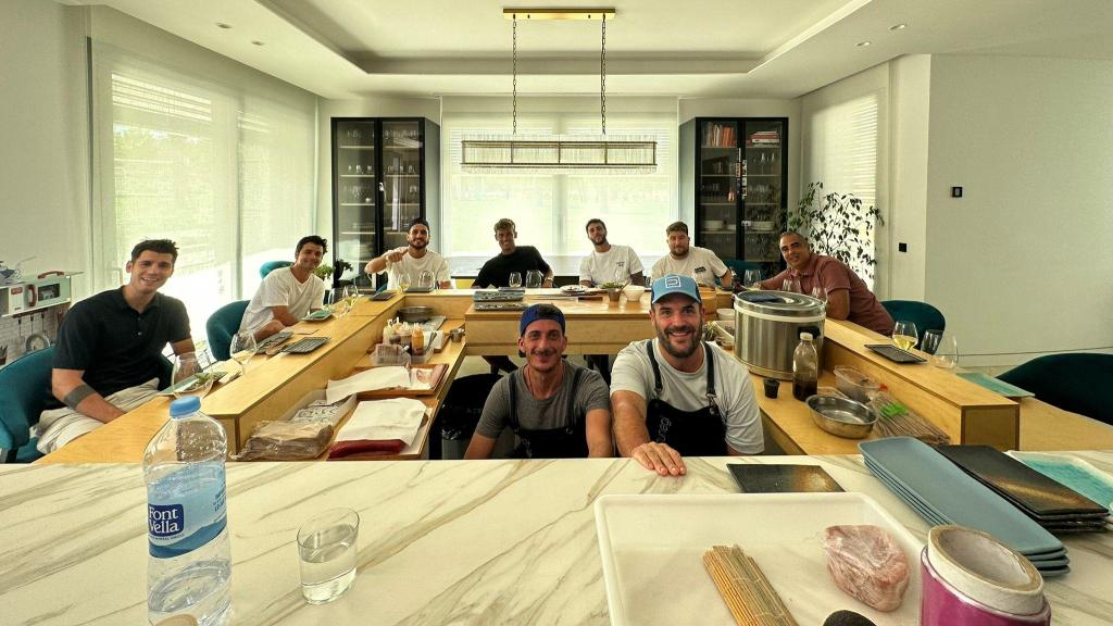 Borja Espegel (centro derecha) dentro de su mesa de itamae cocinando para invitados del mundo del fútbol como Álvaro Morata (izquierda).