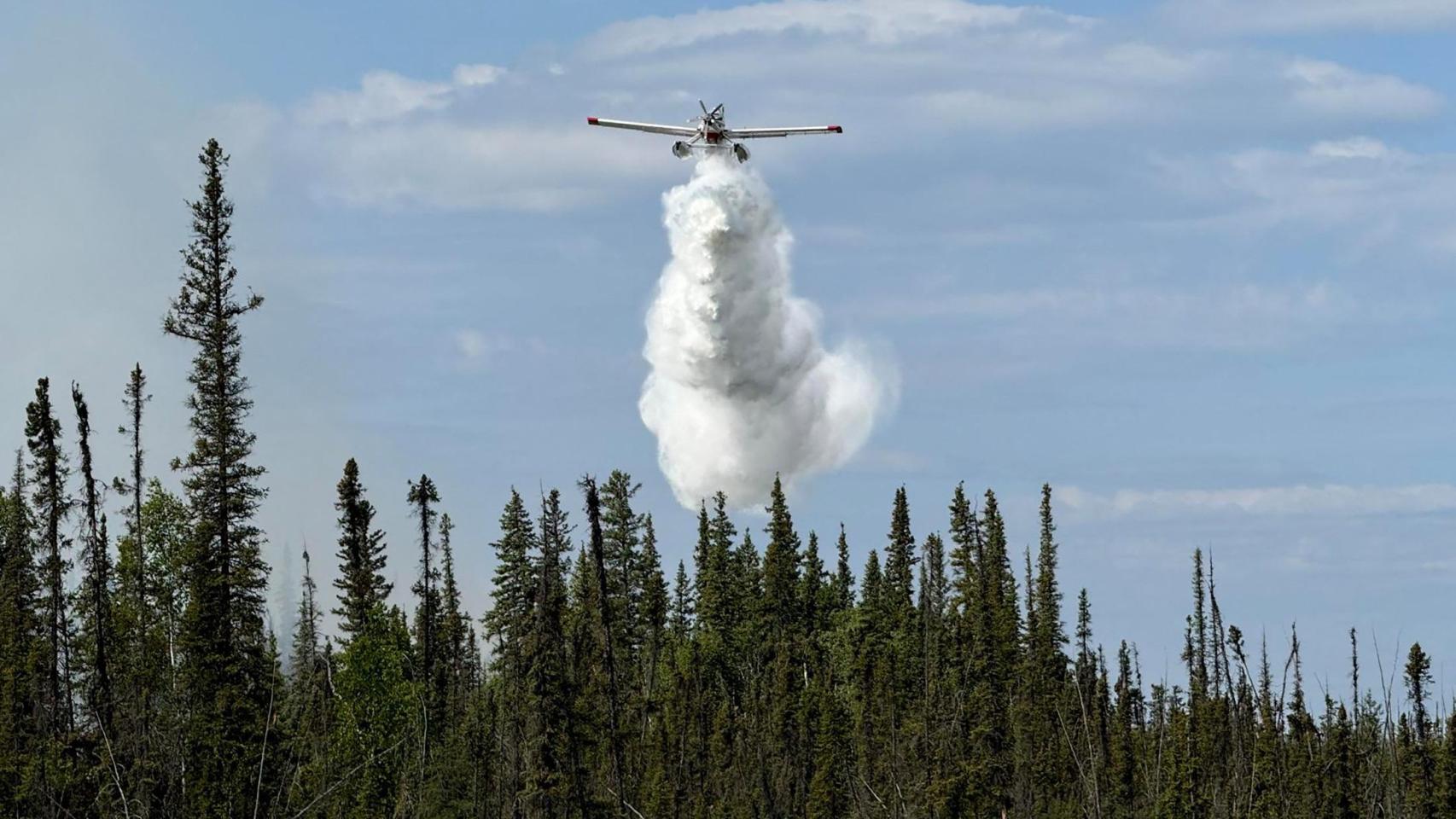 Una avioneta combate los incendios que asuelan los bosques de Canadá.