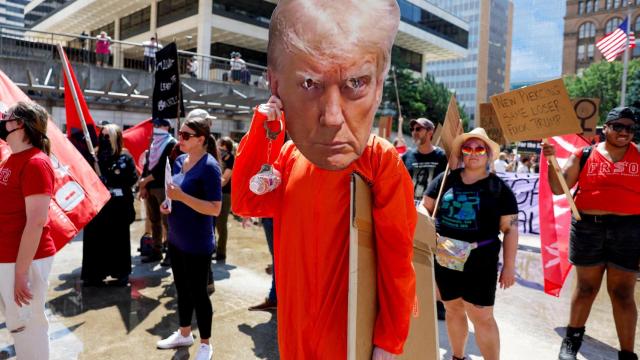 Una persona disfrazada de prisionero lleva un recorte de la cara de Donald Trump, este lunes en Milwaukee.