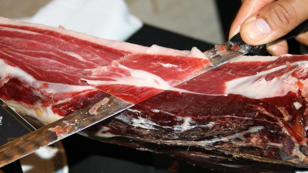 Un cortador de jamón se afana con una pieza.