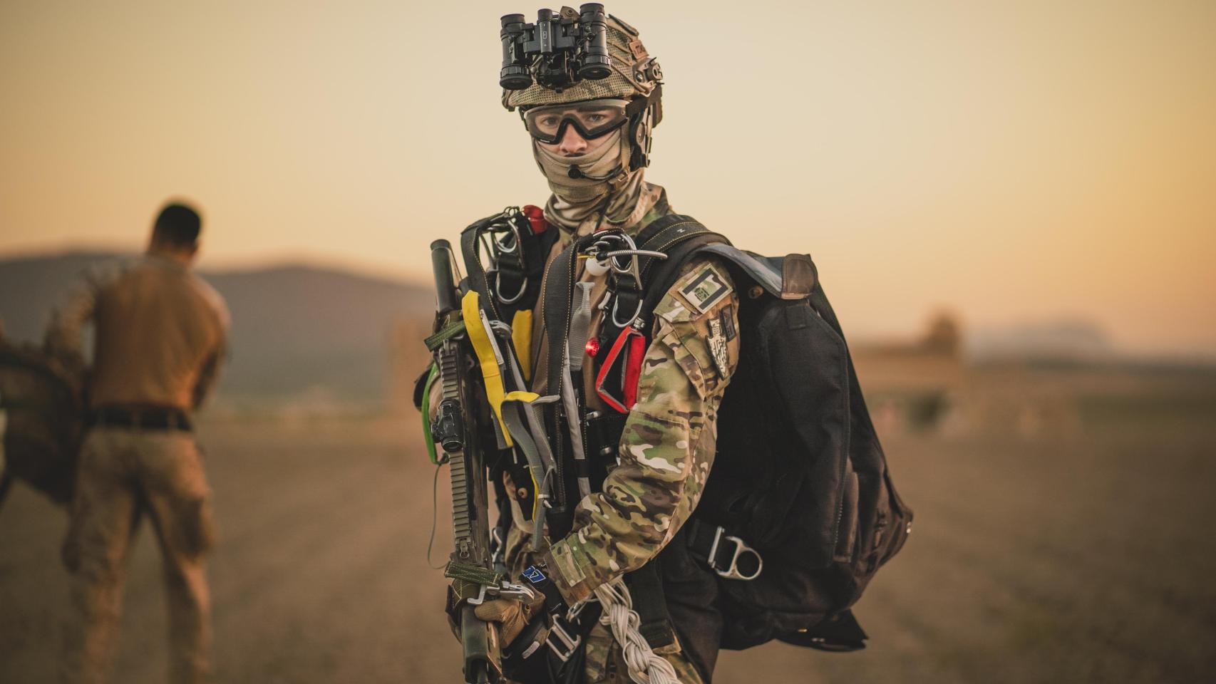 Un miembro del EZAPAC se encuentra empuñando su arma tras tocar tierra. Se pueden ver el arnés así como los mandos de la campana en aún equipados así como su casco con la visión nocturna.