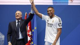 Florentino Pérez levanta la mano de Mbappé en plena presentación.