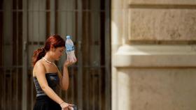 Una mujer con una botella de agua fría.