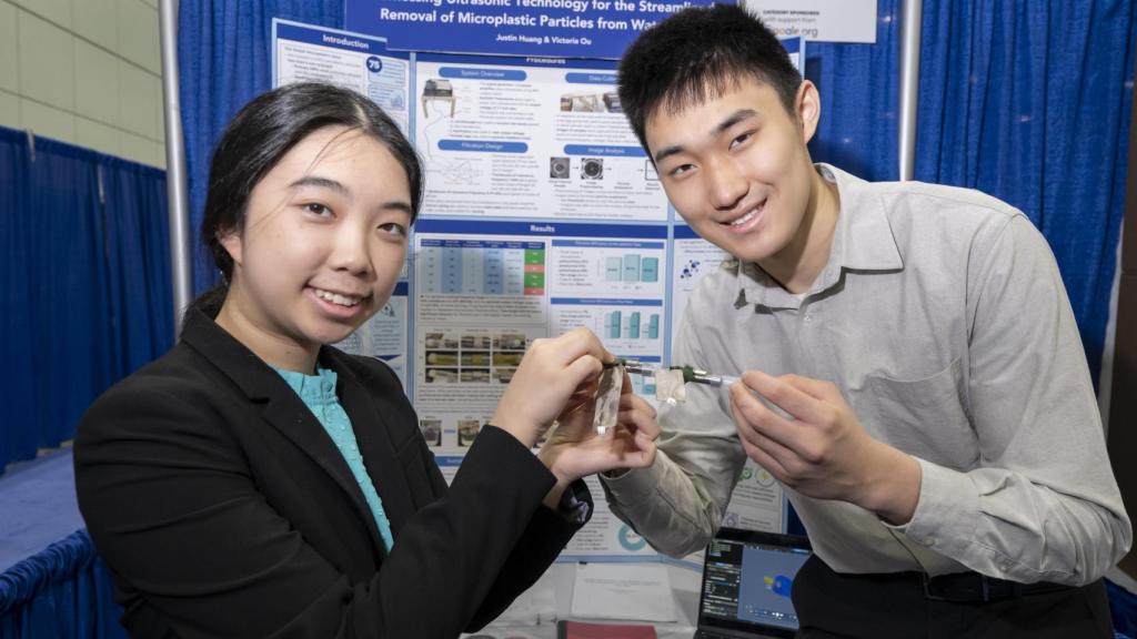 Victoria Ou y Justin Huang mostrando su proyecto para eliminar de microplásticos.