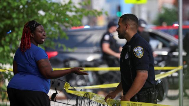 Una mujer habla con un agente cerca del lugar donde se ha producido el tiroteo en Milwaukee.