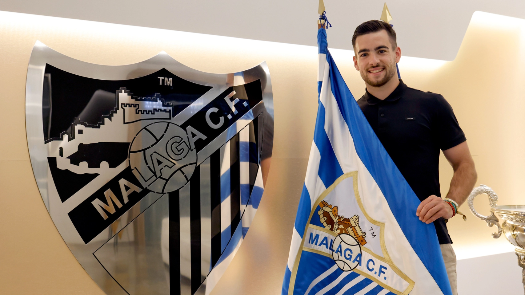 Ramón posando junto a la bandera del Málaga CF.