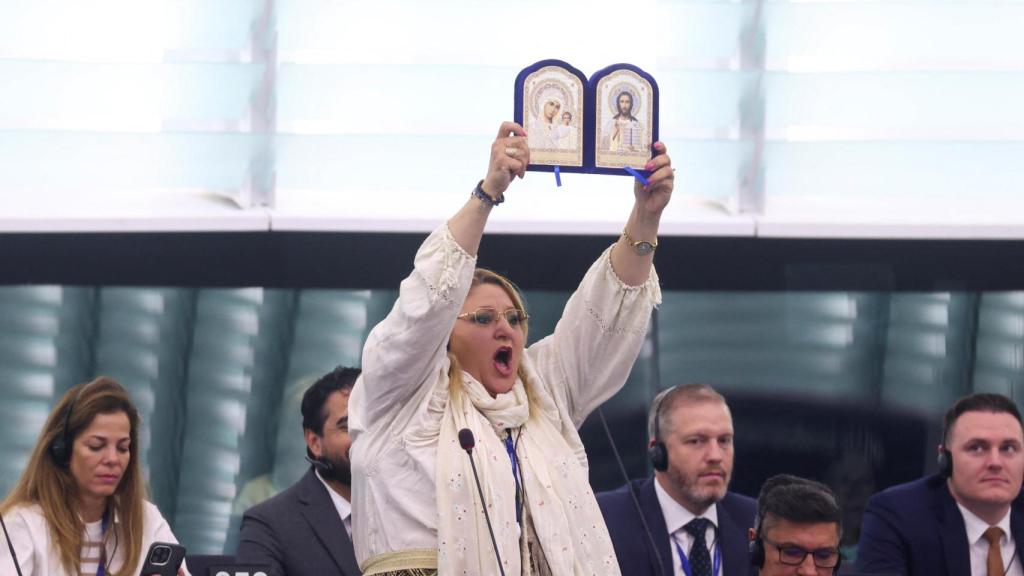 La eurodiputada rumana con las imágenes religiosas antes de ser expulsada del hemiciclo.