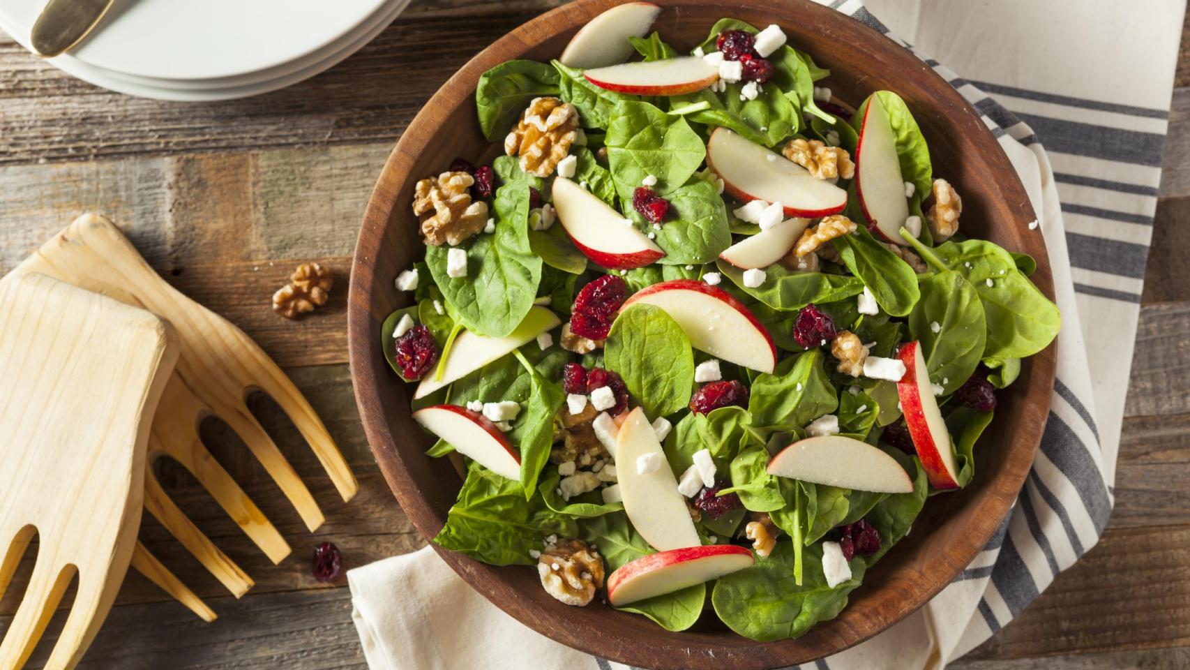 Una ensalada de espinacas, manzanas, nueces y queso