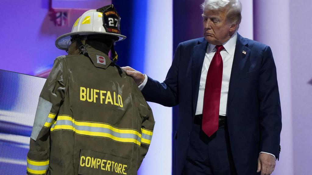 Trump junto al chaleco y el casco de Corey Comperatore, el bombero que murió al recibir uno de los disparos .